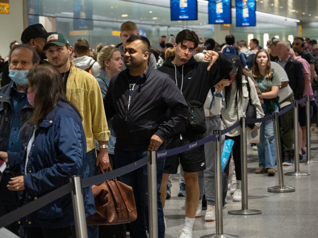 Travellers wait in a long queue to pass through the security check at Heathrow