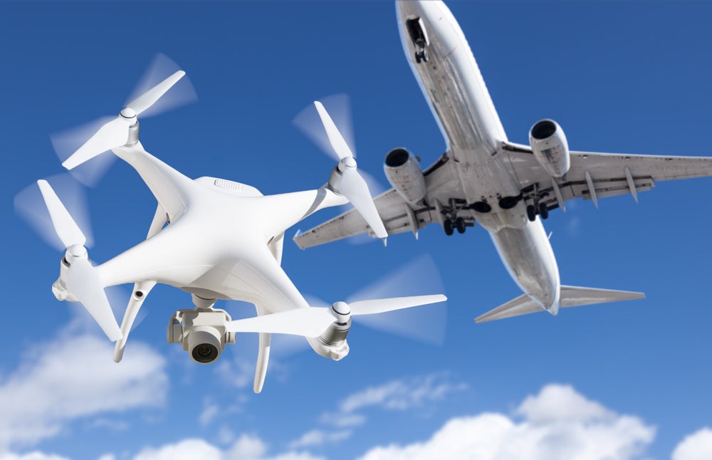 photo of a UAV drone flying underneath a passenger aircraft in integrated airspace