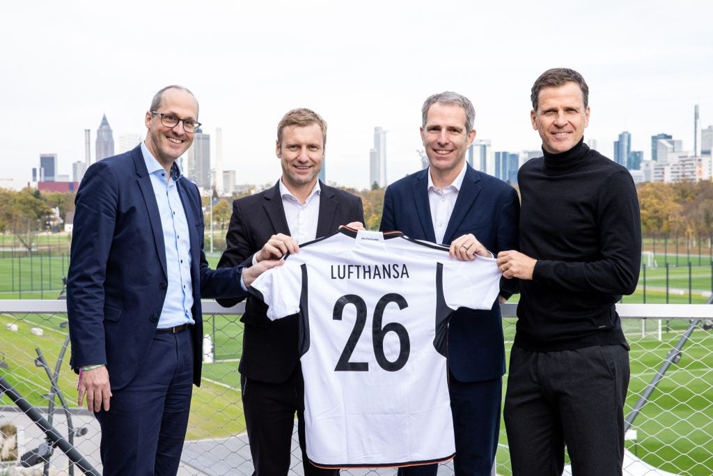 Exectutives holding a German National Team Jersey with the Lufthansa name printed on the back. Qatar Airways Manchester CIty; Etihad Airways