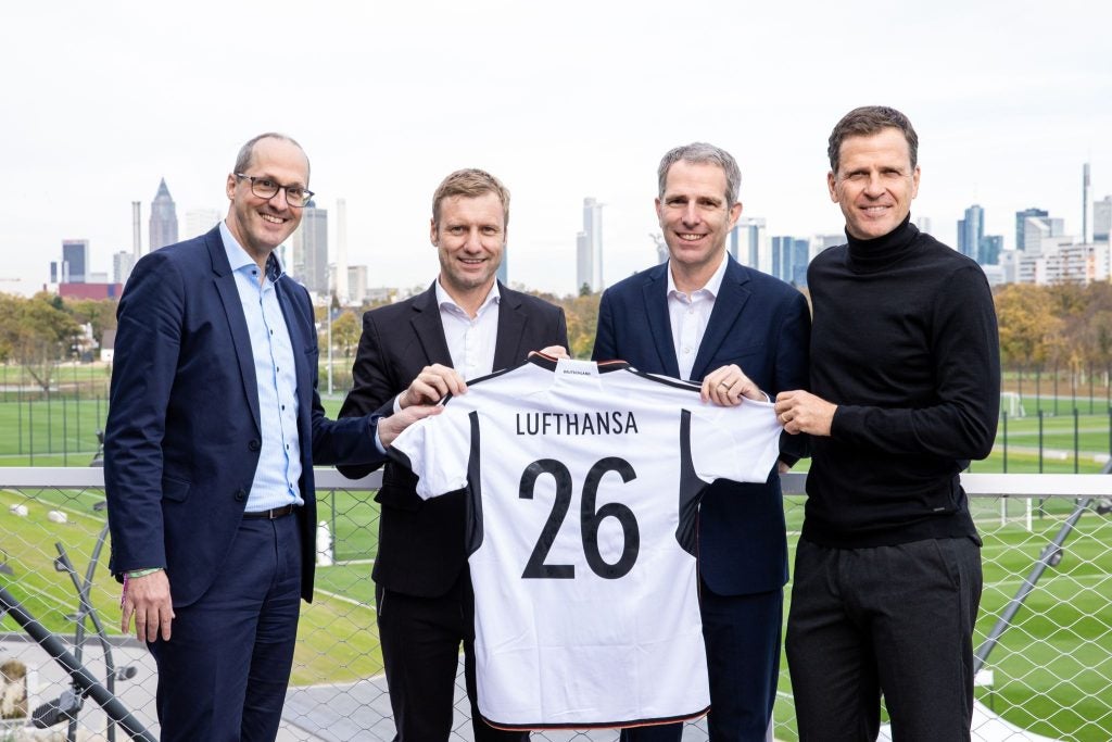 Los ejecutivos sostienen una camiseta de la selección alemana con el nombre de Lufthansa impreso en la espalda.  Ciudad de Manchester de Qatar Airways;  Aerolíneas Etihad