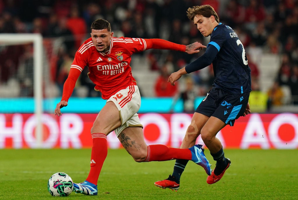 A Benfica player during a match  wearing an Emirates sponsored shirt