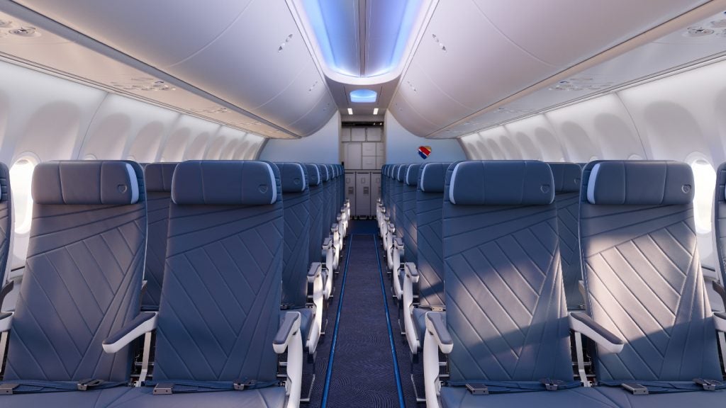 A new Southwest cabin interior with deep blue seats and carpet with sky blue accents, and a southwest heart logo on the rear wall